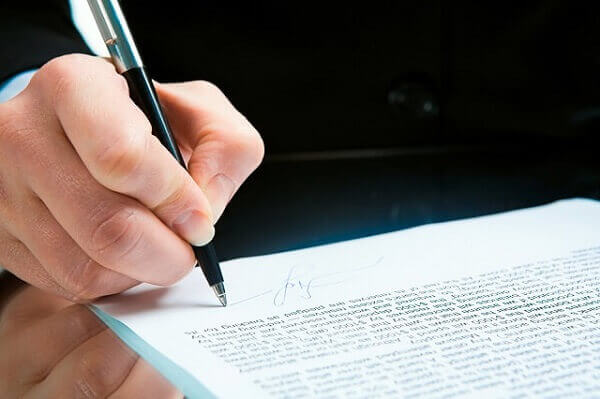 man signing documents