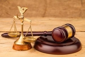 court mallet on a desk next to scales of justice