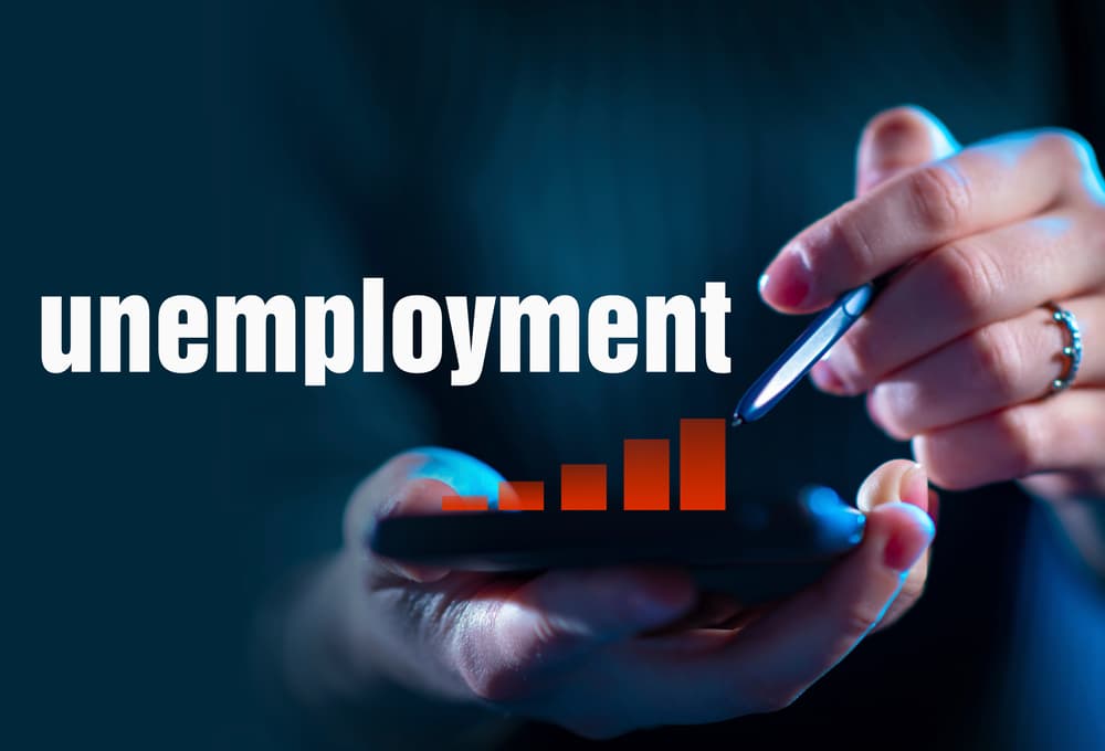 Rising unemployment during a recession shown with a woman drawing a growing graph on glass. Economic crisis deepens. Large Aplan Unemployment logo in view.