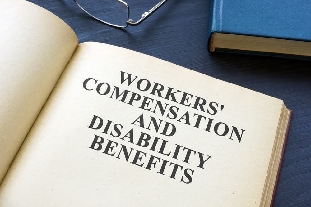 An open law book on Workers' Compensation and Disability Benefits.